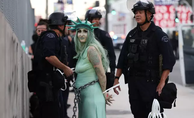 Police arrest a protestor dressed as the Statue of Liberty in downtown Los Angeles after the "No Kings" rally Saturday, March 28, 2026. (AP Photo/Jill Connelly)