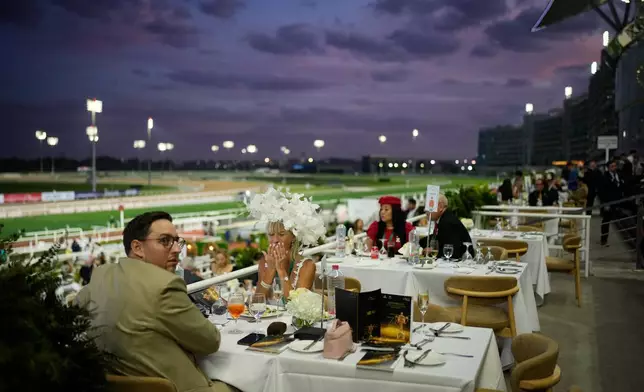 Racegoers dine at in the grandstand during the Dubai World Cup at Meydan Racecourse in Dubai, United Arab Emirates, Saturday, March 28, 2026. (AP Photo/Altaf Qadri)