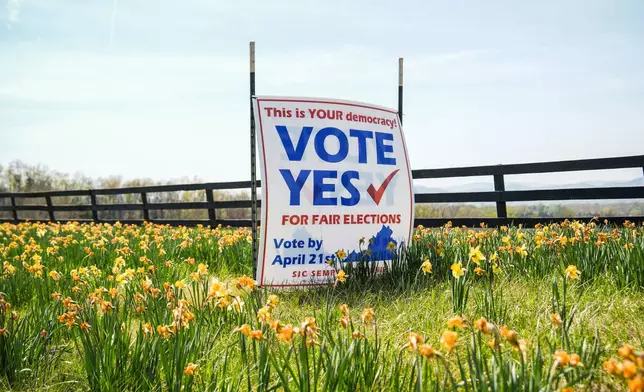 A sign supporting the Virginia redistricting referendum stands among flowers Friday, April 3, 2026, in Madison, Va. (AP Photo/Julia Demaree Nikhinson)