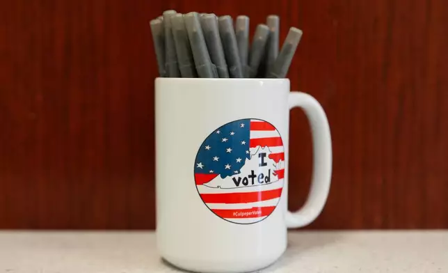 A mug holds pens at the Culpeper County Voter Registration office during the early voting period in the Virginia redistricting referendum, Friday, April 3, 2026, in Culpeper, Va. (AP Photo/Julia Demaree Nikhinson)