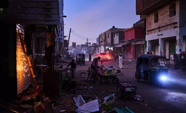 Men work in downtown Omdurman, Sudan, on the outskirts of Khartoum, Friday, April 17, 2026. (AP Photo/Bernat Armangue)