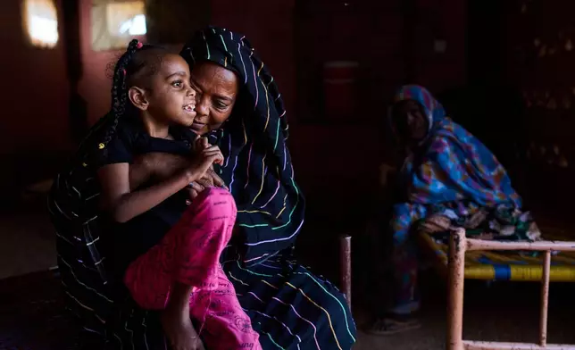Rashiqa Alqadi holds her grandchild, Anfal Aljozoor, 11, who has a disability and suffers from epilepsy, at the family home in Qoz Nafisa village, Khartoum state, Sudan, Wednesday, April 22, 2026. (AP Photo/Bernat Armangue)