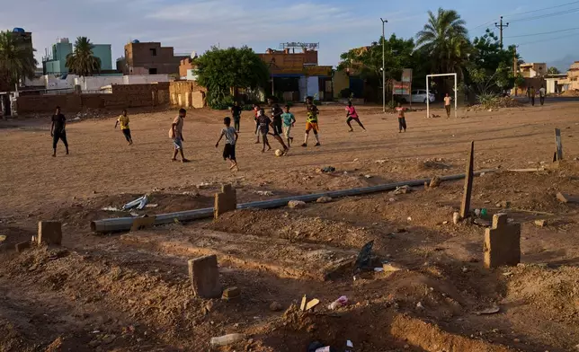Children play soccer in a public park next to an improvised graveyard from the war in Omdurman, on the outskirts of Khartoum, Sudan, Thursday, April 23, 2026. (AP Photo/Bernat Armangue)
