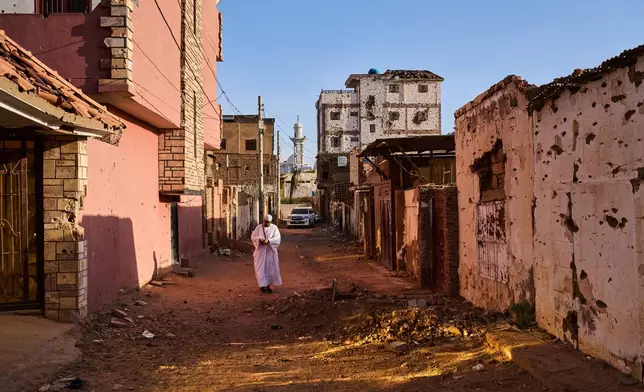 A man walks along a street damaged during the war in Omdurman, Sudan, on the outskirts of Khartoum, Friday, April 17, 2026. (AP Photo/Bernat Armangue)