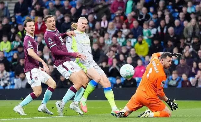 Manchester City's Erling Haaland, second right, scores his side's opening goal during the Premier League soccer match between Burnley and Manchester City in Burnley, England, Wednesday, April 22, 2026. (Nick Potts/PA via AP)