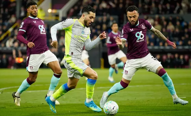Manchester City's Rayan Cherki in action between Burnley's Josh Laurent, left, and Quilindschy Hartman during the Premier League soccer match between Burnley and Manchester City in Burnley, England, Wednesday, April 22, 2026. (AP Photo/Dave Thompson)