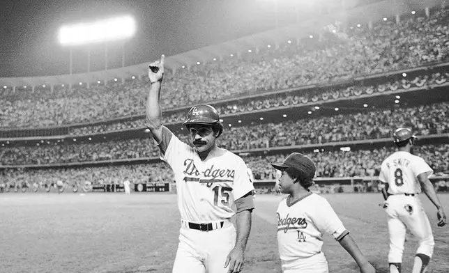 Los Angeles Dodgers Davey Lopes (15) signals to the crowd as he heads to the dugout on Tuesday, Oct. 10, 1978 in Los Angeles after hitting his second two-run home in the first game of the World Series. Youngster at right is Reggie Smith Jr. (AP Photo)