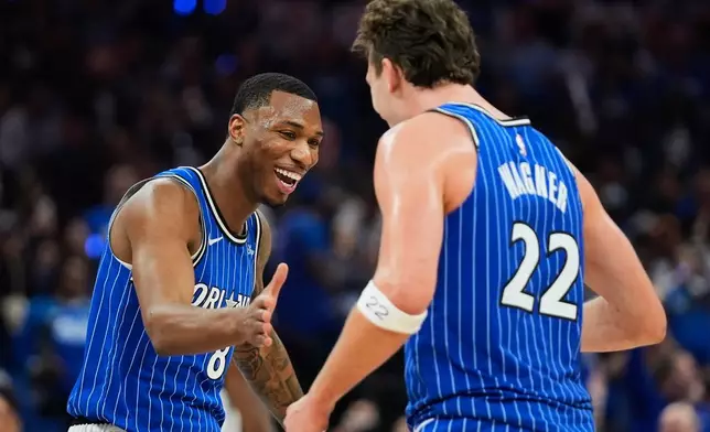 Orlando Magic forward Jamal Cain, left, celebrates a big play against the Charlotte Hornets with forward Franz Wagner (22) during the second half of an NBA play-in tournament basketball game, Friday, April 17, 2026, in Orlando, Fla. (AP Photo/John Raoux)