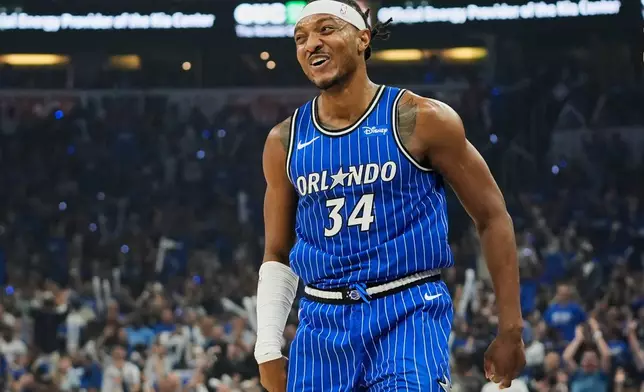 Orlando Magic center Wendell Carter Jr. (34) smiles to teammates after sinking a 3-point shot against the Charlotte Hornets during the first half of an NBA play-in tournament basketball game, Friday, April 17, 2026, in Orlando, Fla. (AP Photo/John Raoux)