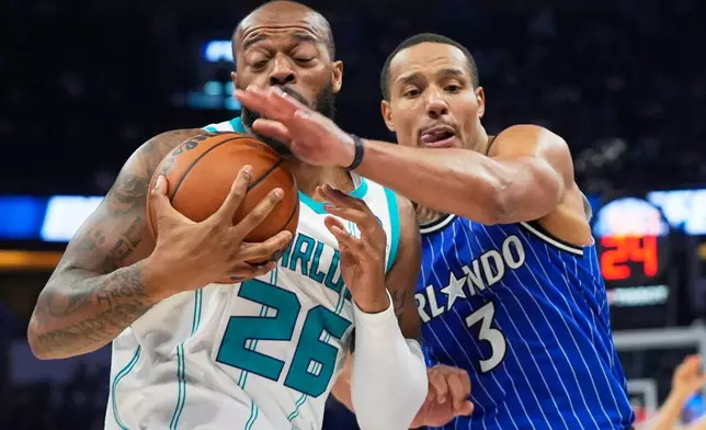 Charlotte Hornets forward Xavier Tillman (26) and Orlando Magic guard Desmond Bane (3) during the second half of an NBA play-in tournament basketball game, Friday, April 17, 2026, in Orlando, Fla. (AP Photo/John Raoux)