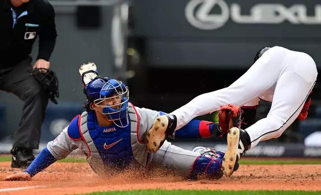 Chicago Cubs catcher Miguel Amaya tags out Cleveland Guardians CJ Kayfus at home plate during the sixth inning of a baseball game, Sunday, April 5, 2026, in Cleveland. (AP Photo/David Dermer)