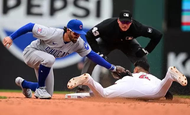 Cleveland Guardians' Brayan Rocchio is tagged out attempting to steal second base by Chicago Cubs shortstop Dansby Swanson during the third inning of a baseball game, Sunday, April 5, 2026, in Cleveland. (AP Photo/David Dermer)