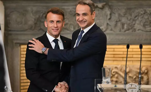 Greece's Prime Minister Kyriakos Mitsotakis, right, shakes hands with France's President Emmanuel Macron after a media conference at Maximos Mansion in Athens, Greece, Saturday, April 25, 2026. (AP Photo/Michael Varaklas)