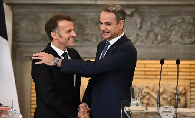 Greece's Prime Minister Kyriakos Mitsotakis, right, shakes hands with France's President Emmanuel Macron after a media conference at Maximos Mansion in Athens, Greece, Saturday, April 25, 2026. (AP Photo/Michael Varaklas)