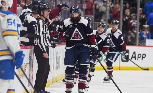Colorado Avalanche defenseman Brent Burns is congratulated as he passes the team box after scoring a goal against the St. Louis Blues in the second period of an NHL hockey game Sunday, April 5, 2026, in Denver. (AP Photo/David Zalubowski)