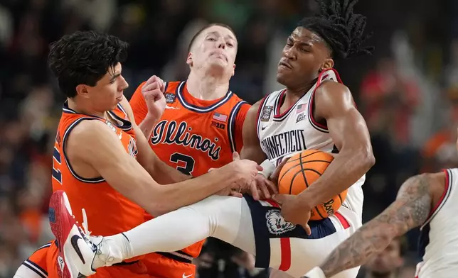 UConn's Silas Demary Jr., right, battle for the ball with Illinois' Andrej Stojakovic, left, and Ben Humrichous during the second half of an NCAA college basketball tournament semifinal game at the Final Four, Saturday, April 4, 2026, in Indianapolis. (AP Photo/Michael Conroy)