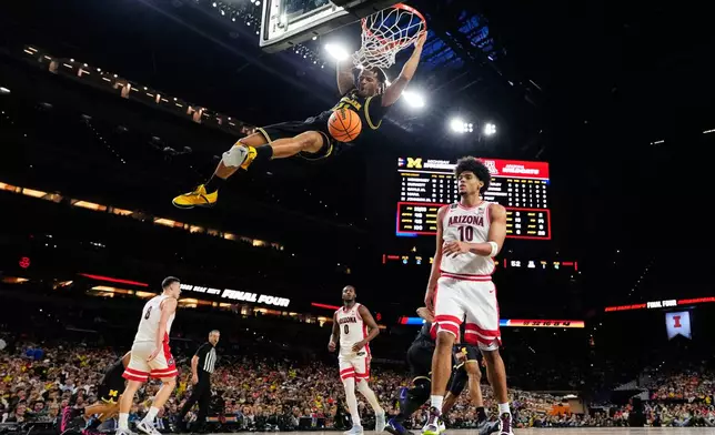 Michigan's Roddy Gayle Jr. (11) dunks over Arizona's Koa Peat (10) during the second half of an NCAA college basketball tournament semifinal game at the Final Four, Saturday, April 4, 2026, in Indianapolis. (AP Photo/Michael Conroy)