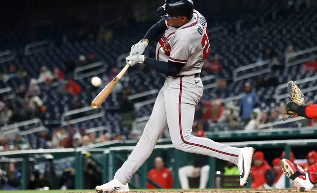 Atlanta Braves' Matt Olson hits a sacrifice fly during the ninth inning of a baseball game against the Washington Nationals, Monday, April 20, 2026, in Washington. (AP Photo/Daniel Kucin Jr.)