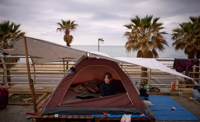 Zahra, 6, displaced from Beirut's southern suburb of Dahiyeh, sits inside a tent used as a shelter along the beachfront in Beirut, Lebanon, Thursday, March 26, 2026. (AP Photo/Emilio Morenatti)