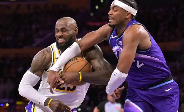 Los Angeles Lakers forward LeBron James, left, is fouled by Utah Jazz forward Blake Hinson (2) as he drives to the basket during the first half of an NBA basketball game Sunday, April 12, 2026, in Los Angeles. (AP Photo/Jayne Kamin-Oncea)