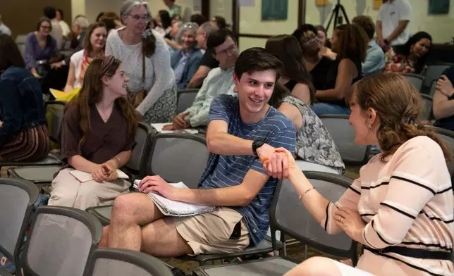 Itai Citrin shakes the hand of another attendee at a talk on climate uncertainty at American University in Washington on April 14, 2026. (AP Photo/Michael Phillis)