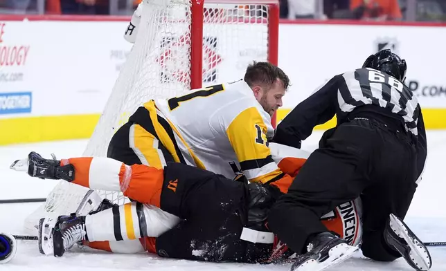 Pittsburgh Penguins' Bryan Rust, left, wrestles with Philadelphia Flyers' Travis Konecny during the second period of Game 3 in the first round of the NHL Stanley Cup hockey playoffs Wednesday, April 22, 2026, in Philadelphia. (AP Photo/Matt Slocum)