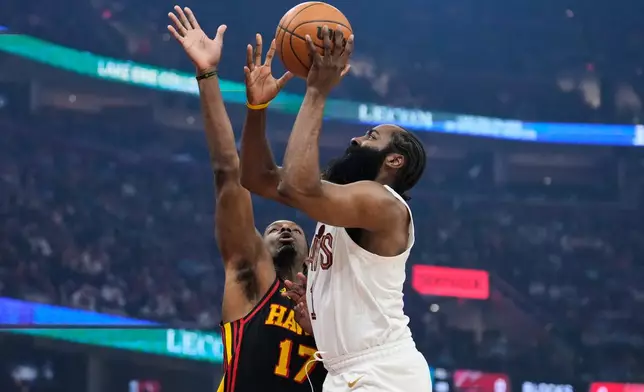 Cleveland Cavaliers guard James Harden, right, shoots as Atlanta Hawks forward Onyeka Okongwu (17) defends in the first half of an NBA basketball game in Cleveland, Wednesday, April 8, 2026. (AP Photo/Sue Ogrocki)