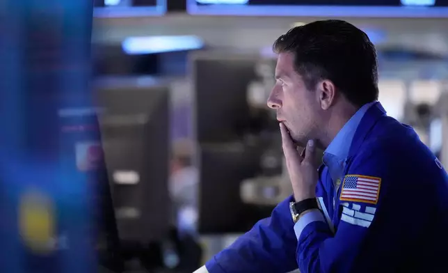People work on the floor at the New York Stock Exchange in New York, Monday, April 13, 2026. (AP Photo/Seth Wenig)