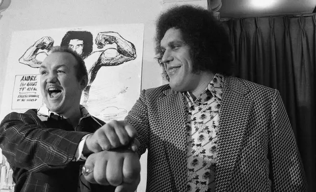 FILE - Heavyweight boxer Chuck Wepner, left, compares fist size with Andre the Giant at a New York news conference on May 4, 1976. (AP Photo/Marty Lederhandler, File)
