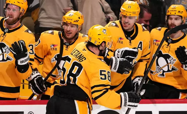 Pittsburgh Penguins' Kris Letang (58) returns to the bench and greetings from Anthony Mantha (39), Sidney Crosby, Evgeni Malkin (71) and Tommy Novak after scoring during the second period of Game 5 in the first round of an NHL hockey Stanley Cup playoff series against the Philadelphia Flyers in Pittsburgh, Monday, April 27, 2026. (AP Photo/Gene J. Puskar)