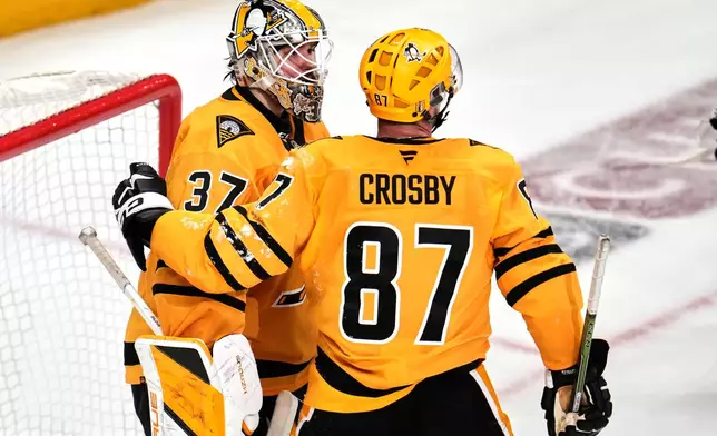 Pittsburgh Penguins goaltender Arturs Silovs (37) celebrates with Sidney Crosby (87) at the end of Game 5 in the first round of an NHL hockey Stanley Cup playoff series in Pittsburgh, Monday, April 27, 2026. (AP Photo/Gene J. Puskar)