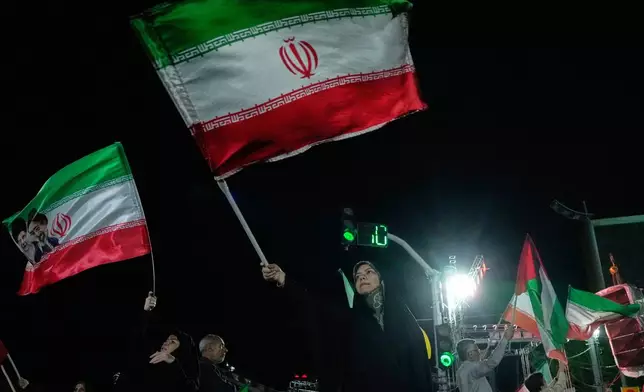 Pro-government demonstrators wave Iranian flags during a gathering in Tehran, Iran, Monday, April 27, 2026. (AP Photo/Vahid Salemi)