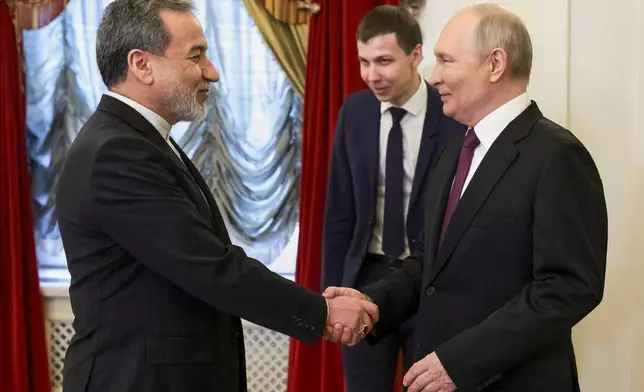 Russian President Vladimir Putin, right, shakes hands with Iranian Foreign Minister Abbas Araghchi during their meeting at the Boris Yeltsin Presidential Library, in St. Petersburg, Russia, Monday, April 27, 2026. (Gavriil Grigorov, Sputnik, Kremlin Pool Photo via AP)