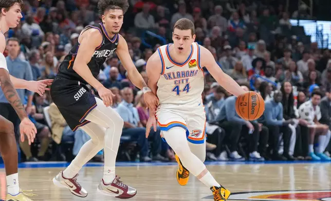 Oklahoma City Thunder guard Nikola Topic, right, drives past Phoenix Suns guard Koby Brea during the second half of an NBA basketball game, Sunday, April 12, 2026, in Oklahoma City. (AP Photo/Kyle Phillips)