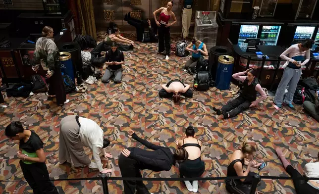 Dancers warm up and stretch before an audition for the Radio City Rockettes at Radio City Music Hall in New York, on Wednesday, April 22, 2026. (AP Photo/Yuki Iwamura)