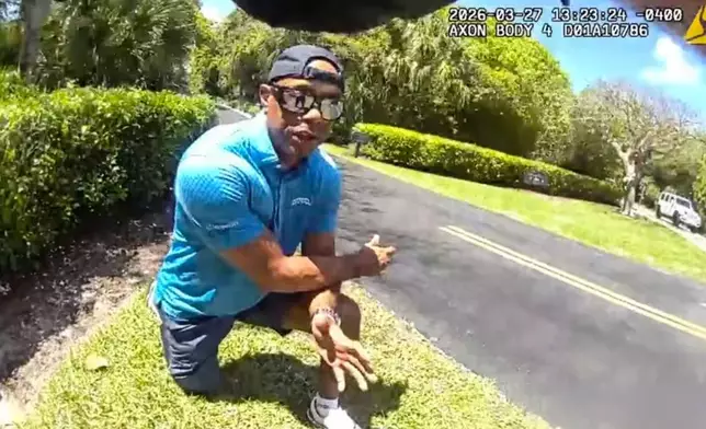 In this image taken from police body camera video released by the Martin County, Fla., Sheriff's Office, golfer Tiger Woods speaks with sheriff's deputies following a car crash in Jupiter Island, Fla., Friday, March 27, 2026. (Martin County Sheriff's Office via AP)