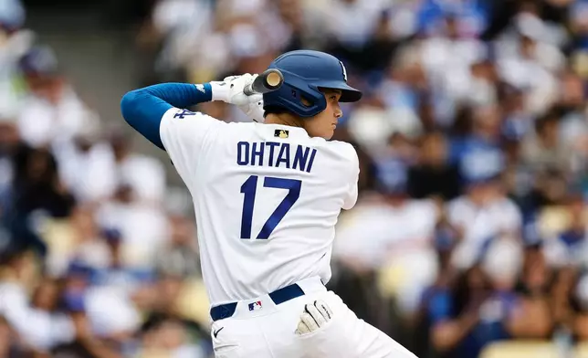 Los Angeles Dodgers designated hitter Shohei Ohtani (17) practices his swing while on deck during the fifth inning of a baseball game against the Texas Rangers, Sunday, April 12, 2026, in Los Angeles. (AP Photo/Caroline Brehman)