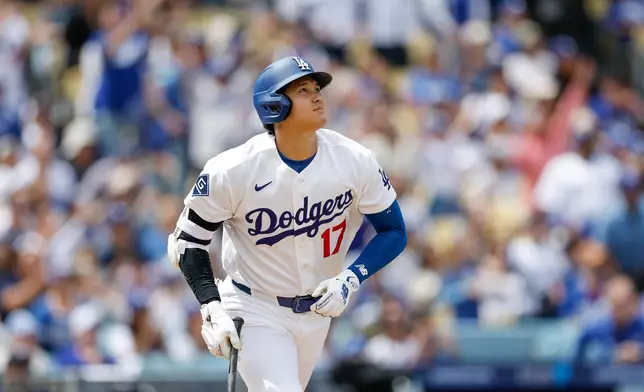 Los Angeles Dodgers designated hitter Shohei Ohtani watches his home run during the first inning of a baseball game against the Texas Rangers, Sunday, April 12, 2026, in Los Angeles. (AP Photo/Caroline Brehman)
