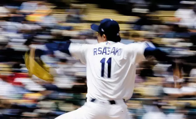 Los Angeles Dodgers starting pitcher Roki Sasaki (11) pitches during the first inning of a baseball game against the Texas Rangers, Sunday, April 12, 2026, in Los Angeles. (AP Photo/Caroline Brehman)
