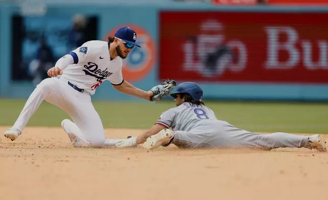 Texas Rangers' Josh Smith (8) slides into second base as Los Angeles Dodgers second baseman Alex Freeland (76) goes to tag him out at second base during the eighth inning of a baseball game Sunday, April 12, 2026, in Los Angeles. (AP Photo/Caroline Brehman)
