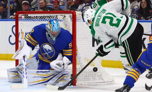 Buffalo Sabres goaltender Colten Ellis (92) stops a shot by Dallas Stars left wing Jason Robertson (21) during the second period of an NHL hockey game Wednesday, April 15, 2026, in Buffalo, N.Y. (AP Photo/Jeffrey T. Barnes)