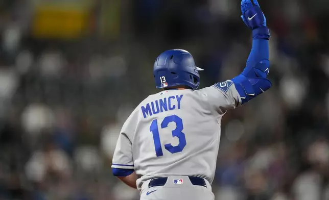 Los Angeles Dodgers' Max Muncy waves to the bullpen as he circles the bases after hitting a solo home run off Colorado Rockies relief pitcher Tanner Gordon in the ninth inning of a baseball game Monday, April 20, 2026, in Denver. (AP Photo/David Zalubowski)