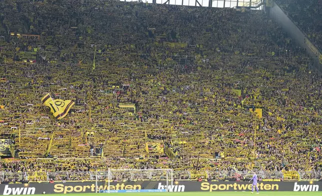 Dortmund' supporters wave their flags during the German Bundesliga soccer match between Borussia Dortmund and Bayer Leverkusen in Dortmund, Germany, Saturday, April 11, 2026. (AP Photo/Martin Meissner)