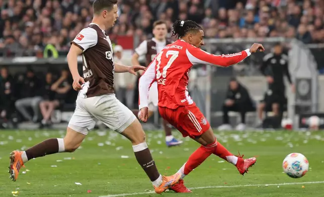 Bayern's Michael Olise, right, scores his side's third goal during the German Bundesliga soccer match between FC St. Pauli and Bayern Munich in Hamburg, Germany, Saturday, April 11, 2026. (Christian Charisius/dpa via AP)