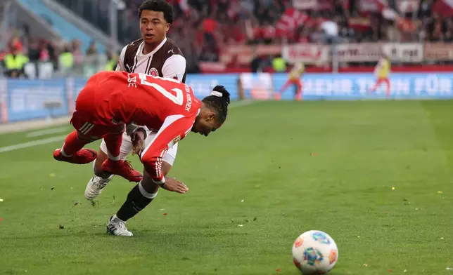 Bayern's Michael Olise is challenged by FC St. Pauli's Joel Chima Fujita during the German Bundesliga soccer match between FC St. Pauli and Bayern Munich in Hamburg, Germany, Saturday, April 11, 2026. (Christian Charisius/dpa via AP)