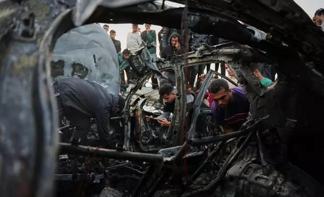 Palestinians inspect a vehicle struck by an Israeli airstrike in the Maghazi refugee camp in the central Gaza Strip, Saturday, April 4, 2026. (AP Photo/Abdel Kareem Hana)