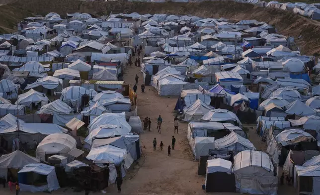 Palestinians walk along tents at a makeshift camp for displaced people in Khan Younis, southern Gaza Strip, Thursday, April 9, 2026. (AP Photo/Abdel Kareem Hana)
