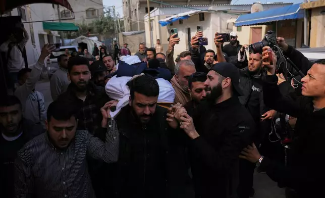 Mourners carry the body of Al Jazeera correspondent Mohammed Wishah, who was killed in an Israeli strike on his vehicle, during his funeral outside Al-Aqsa Hospital in Deir al-Balah, central Gaza Strip, Thursday, April 9, 2026. (AP Photo/Abdel Kareem Hana)
