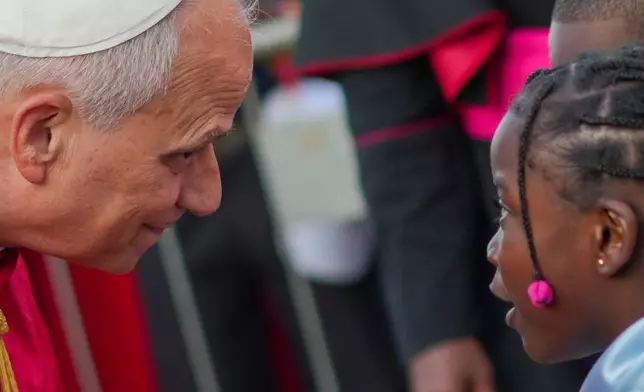 Pope Leo XIV listens to a girl as he arrives at the Parish of Our Lady of Fatima in Luanda, Angola, for a meeting with bishops, priests, consecrated men and women, and pastoral workers Monday, April 20, 2026, on the eighth day of an 11-day apostolic journey to Africa (AP Photo/Andrew Medichini)