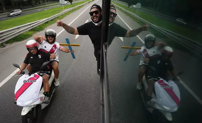 River Plate fans ride a bus followed by motorcycles on their way to the stadium for an Argentine league match against Boca Juniors in Buenos Aires, Argentina, Sunday, April 19, 2026. (AP Photo/Rodrigo Abd)